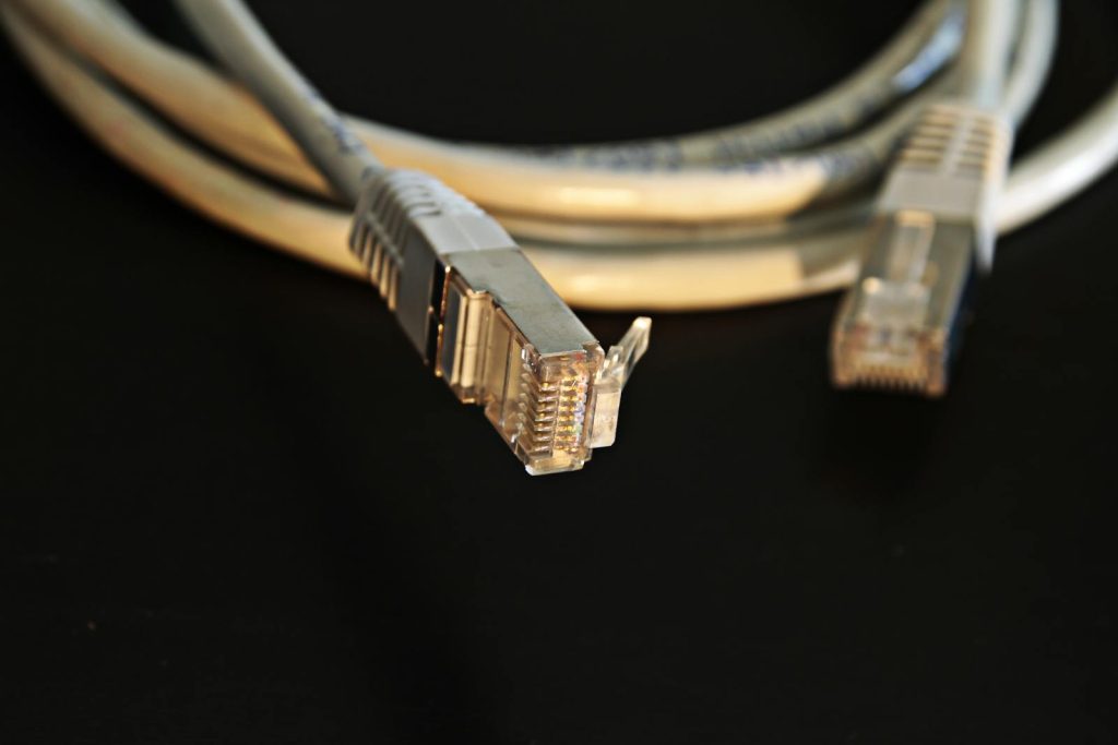 Detailed close-up of a network Ethernet cable showing connectors on a black background.